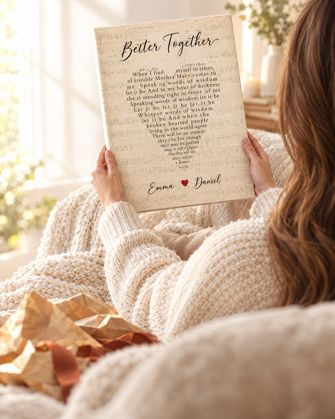 Woman holding up a personalized song lyrics canvas she just unwrapped